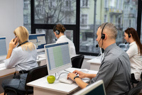 Grupo de personas trabajando en soporte técnico con auriculares y computadoras.